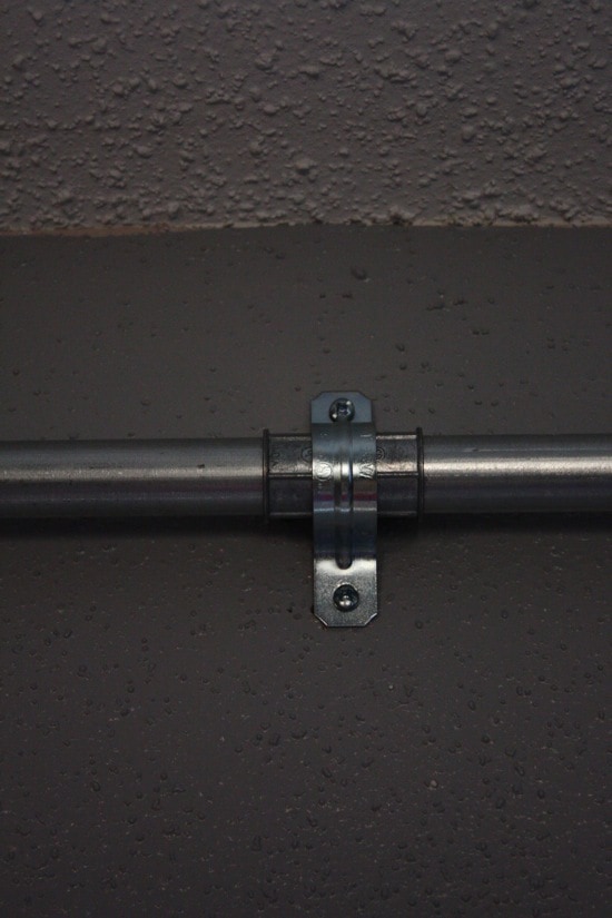 close up of two hole strap holding curtain rod to wall
