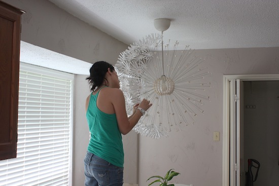 Woman putting flowers on an IKEA MASKROS light