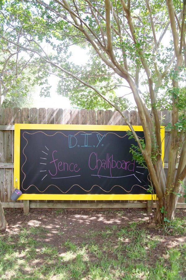 chalkboard hanging on a fence with words written on it - DIY fence chalkboard