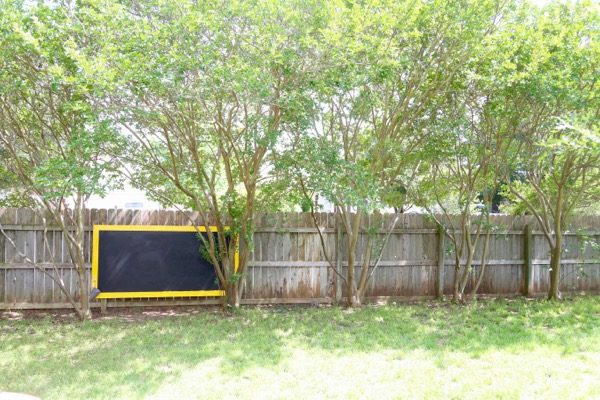 outdoor chalkboard hanging on a fence