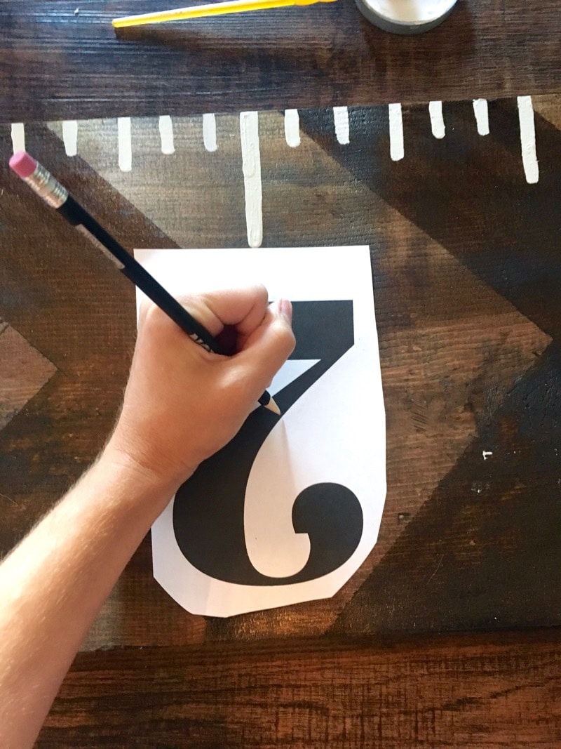 woman tracing a number onto a piece of wood