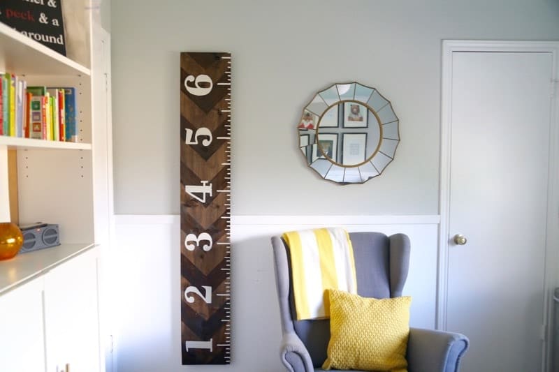 A young boy's room with a wooden growth chart on the wall