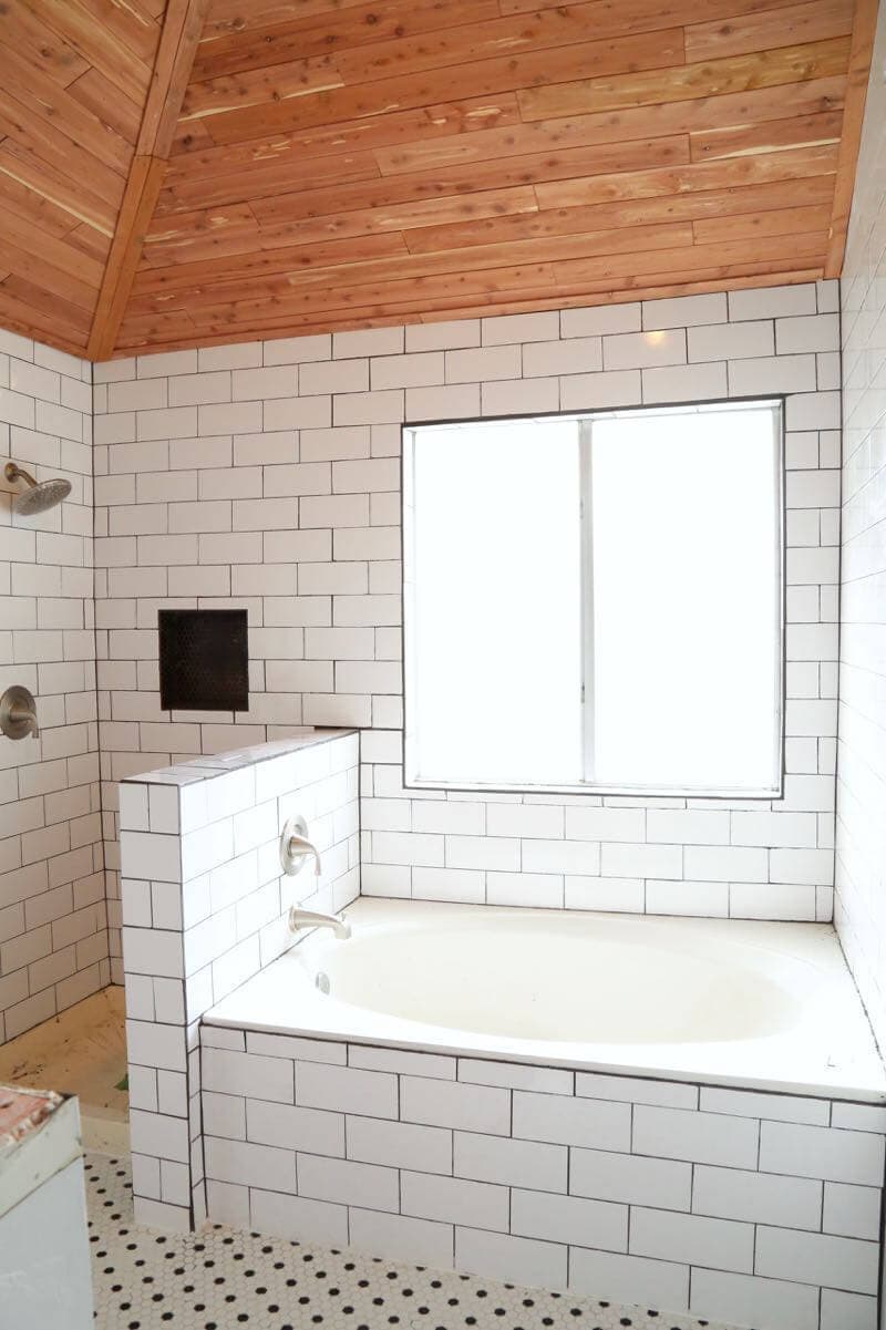 This master bathroom is so clean, bright, and serene! Love the black and white tile and the cedar planked ceiling!