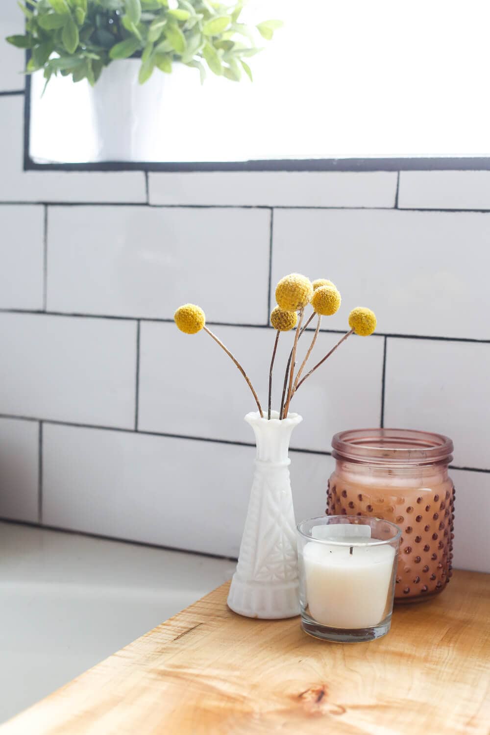 candles and flowers on top of bathtub tray