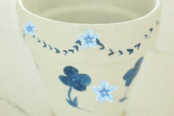 white pot painted with blue flowers