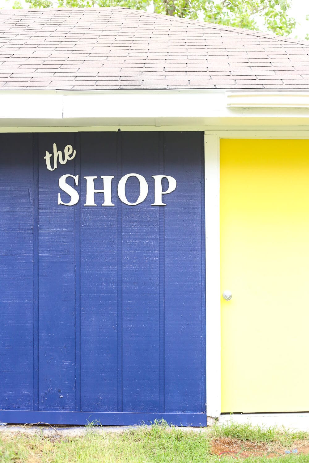 a backyard workshop with a wooden sign with letters cut out of wood