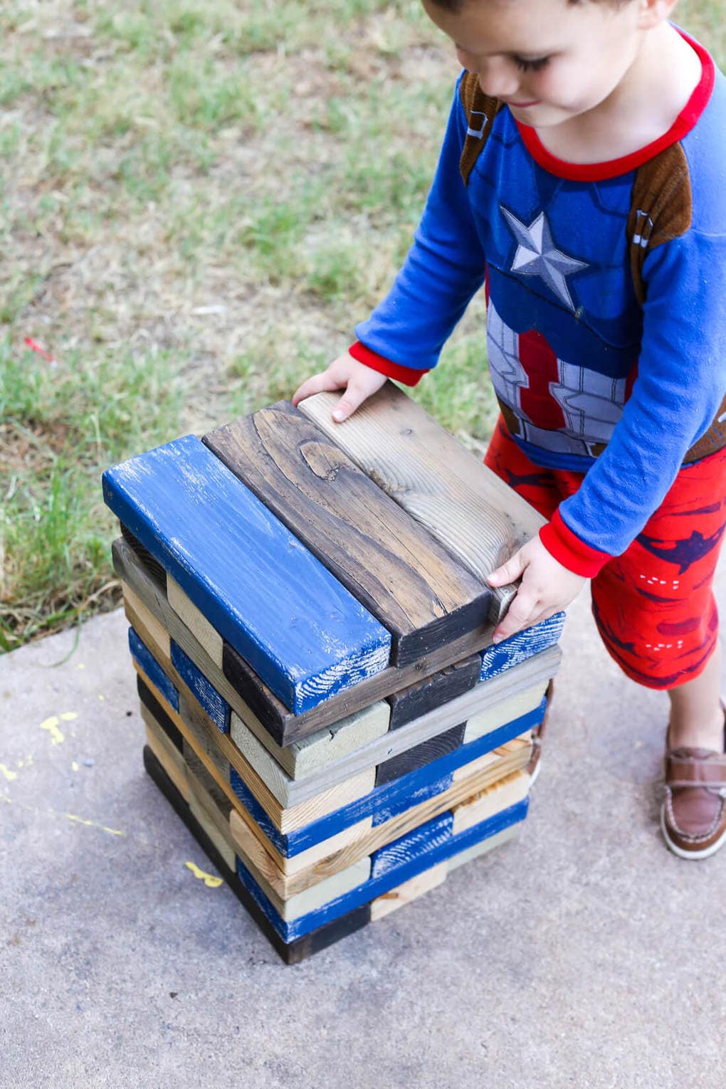 young boy playing backyard jenga