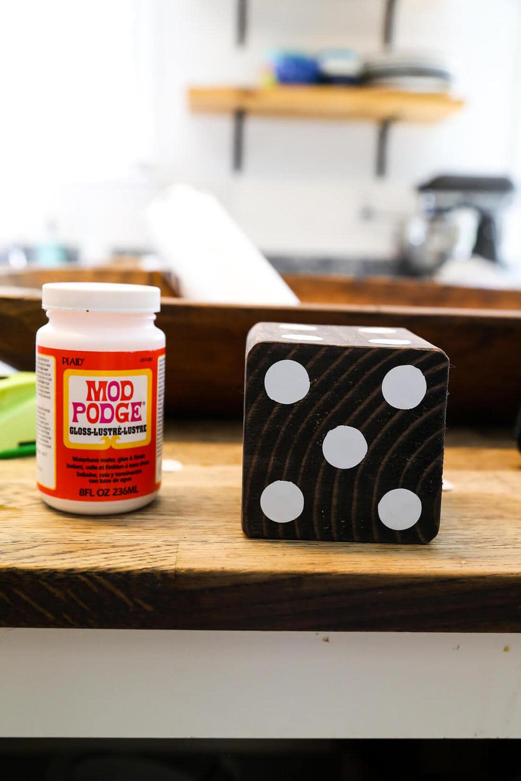 Wooden yard dice next to a jar of Mod Podge