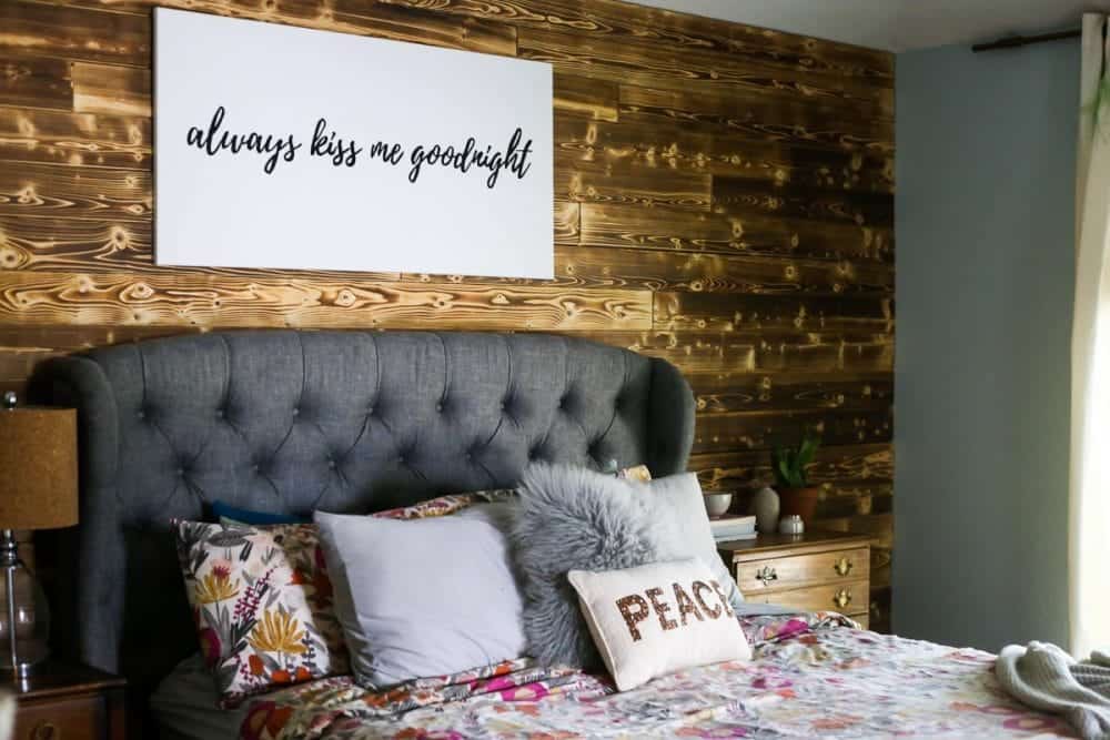 master bedroom with a charred wood accent wall behind the bed 