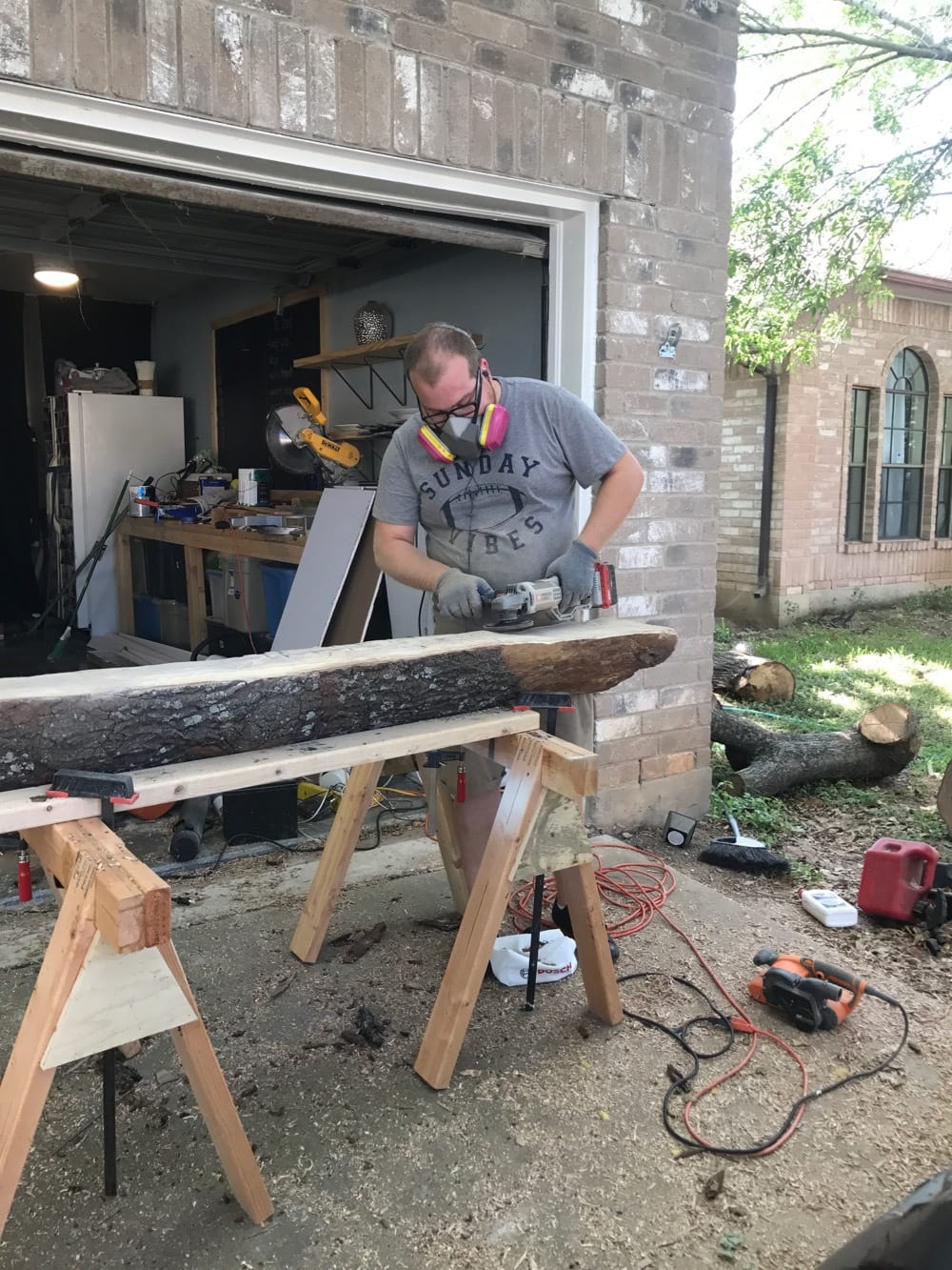 man using a grinder on a piece of tree 