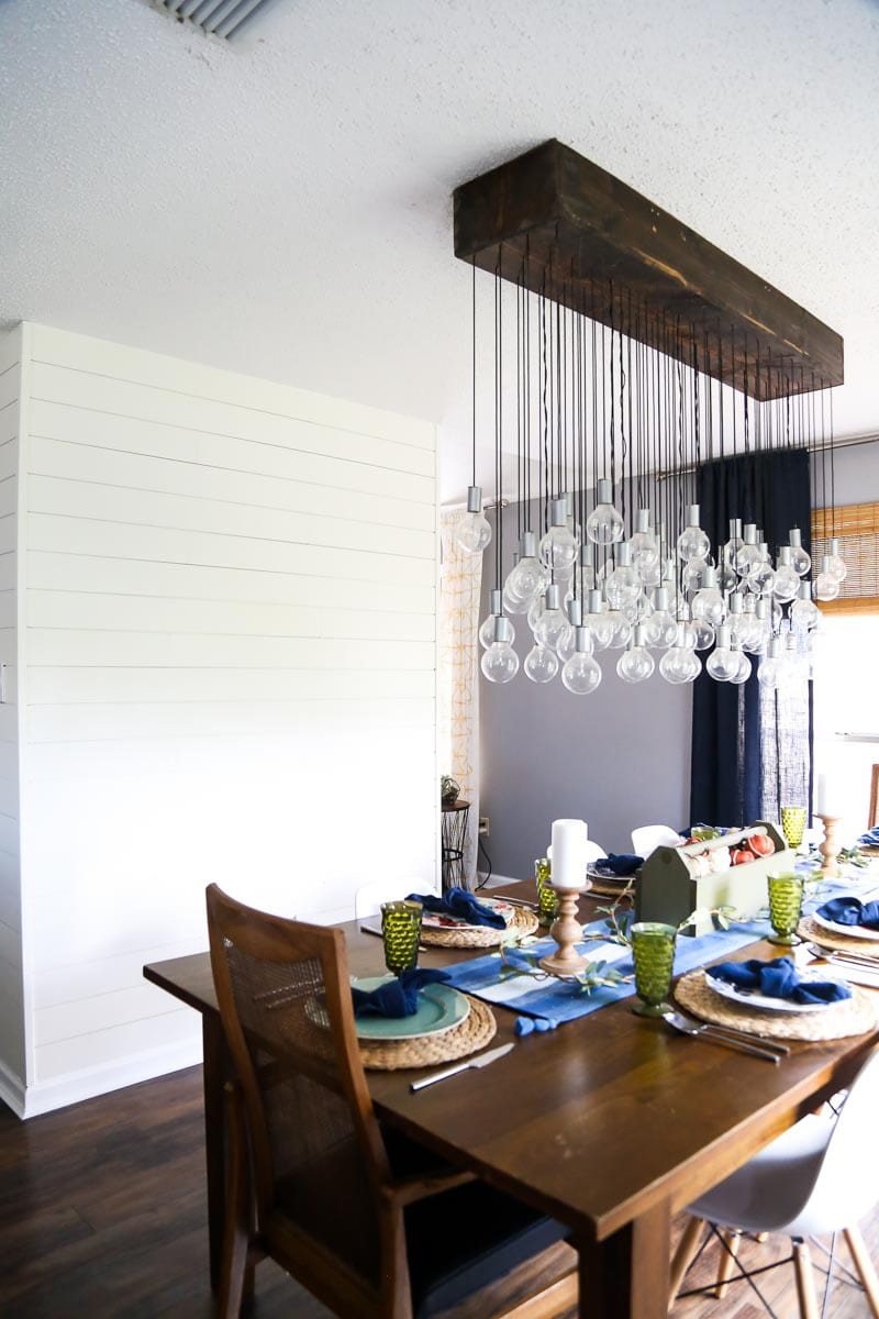 a dining room with a large multi-bulb chandelier over the dining table