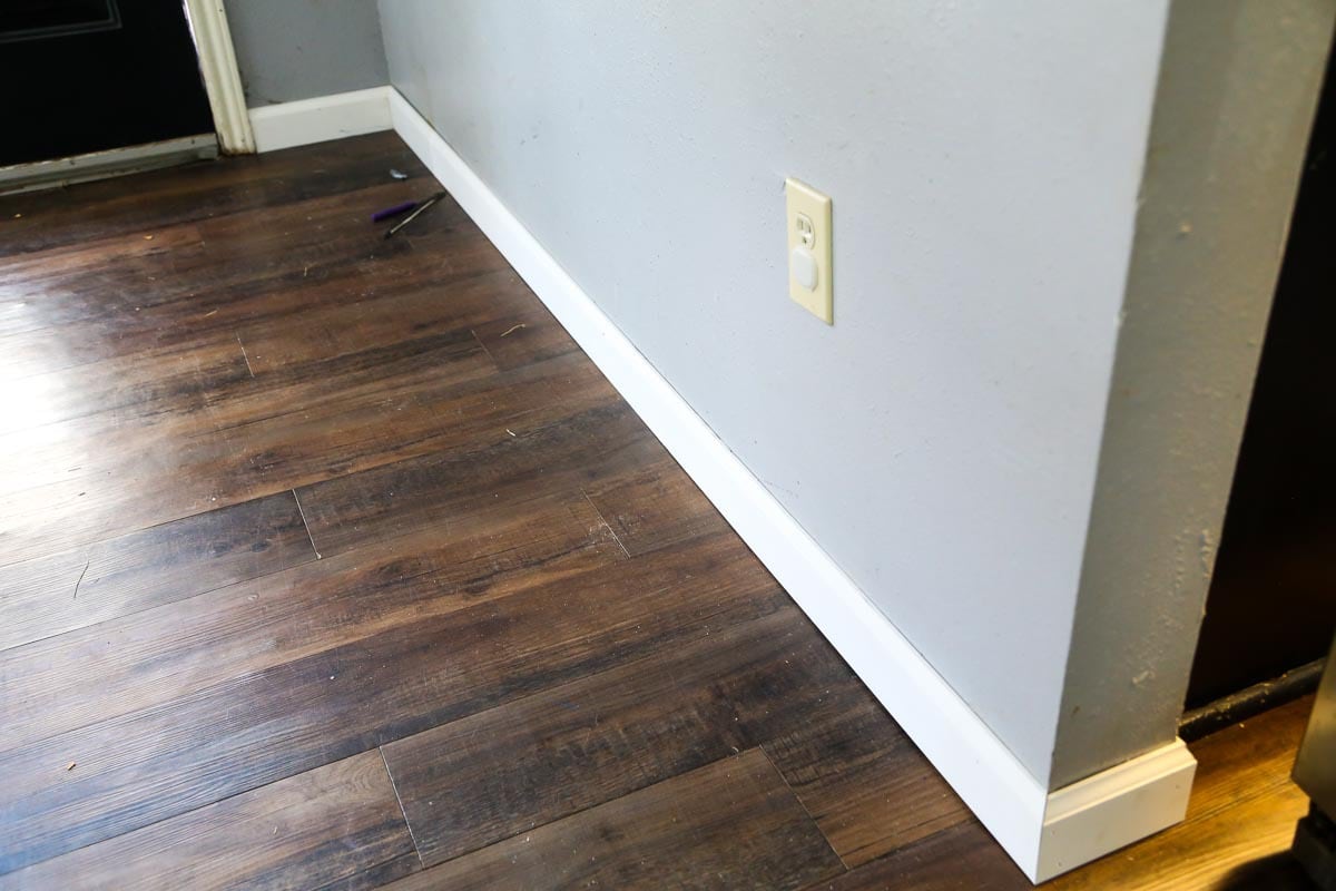 baseboards being installed on the outside corner of a wall 