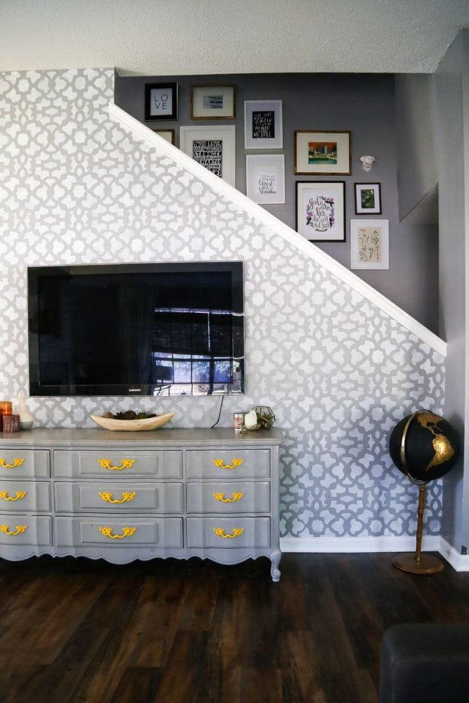 living room with a staircase gallery wall and a stenciled accent wall 