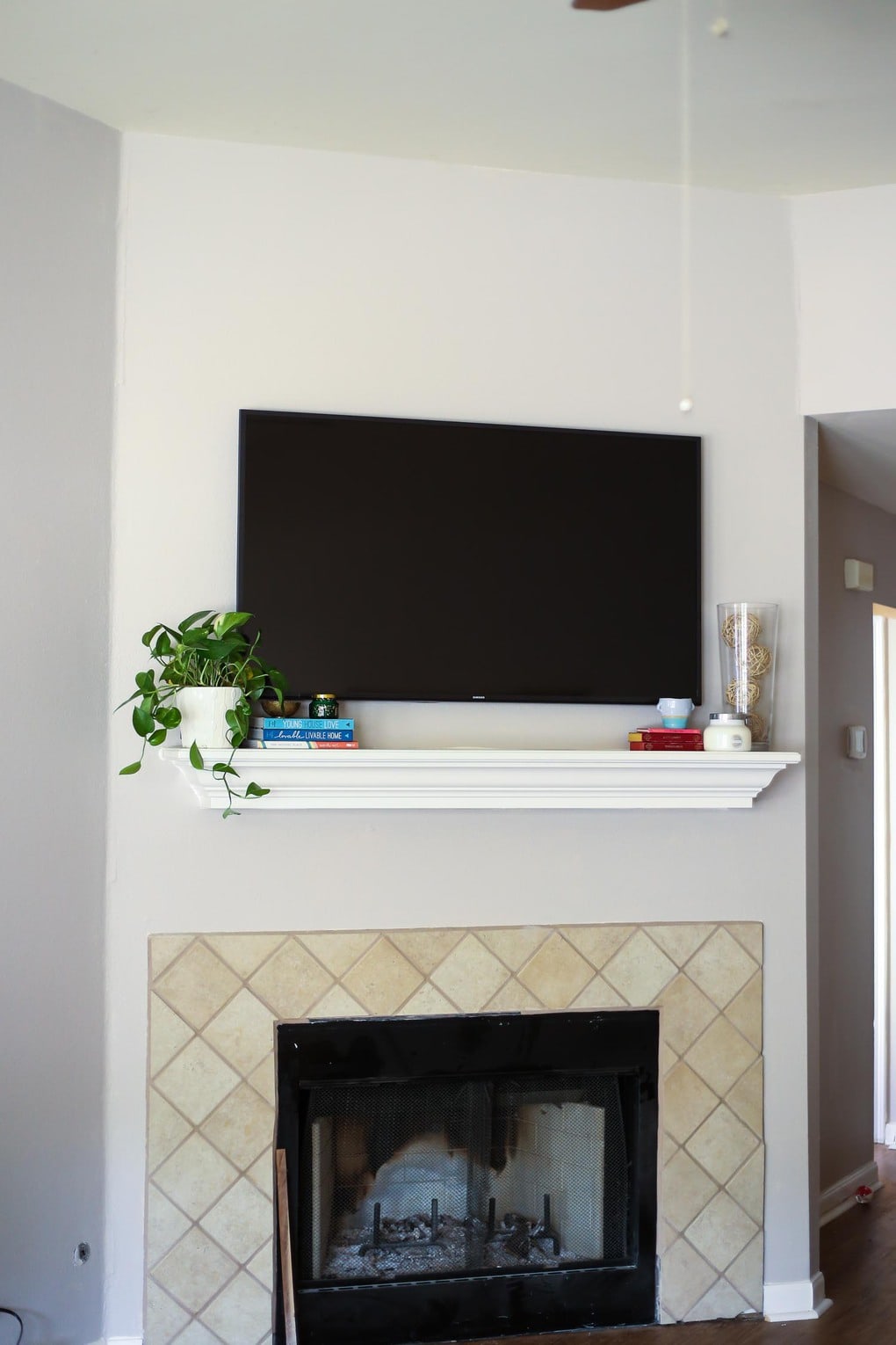 Tips for decorating a mantel when you have a television hanging above it - how to make the most of an awkward setup and make it beautiful! 