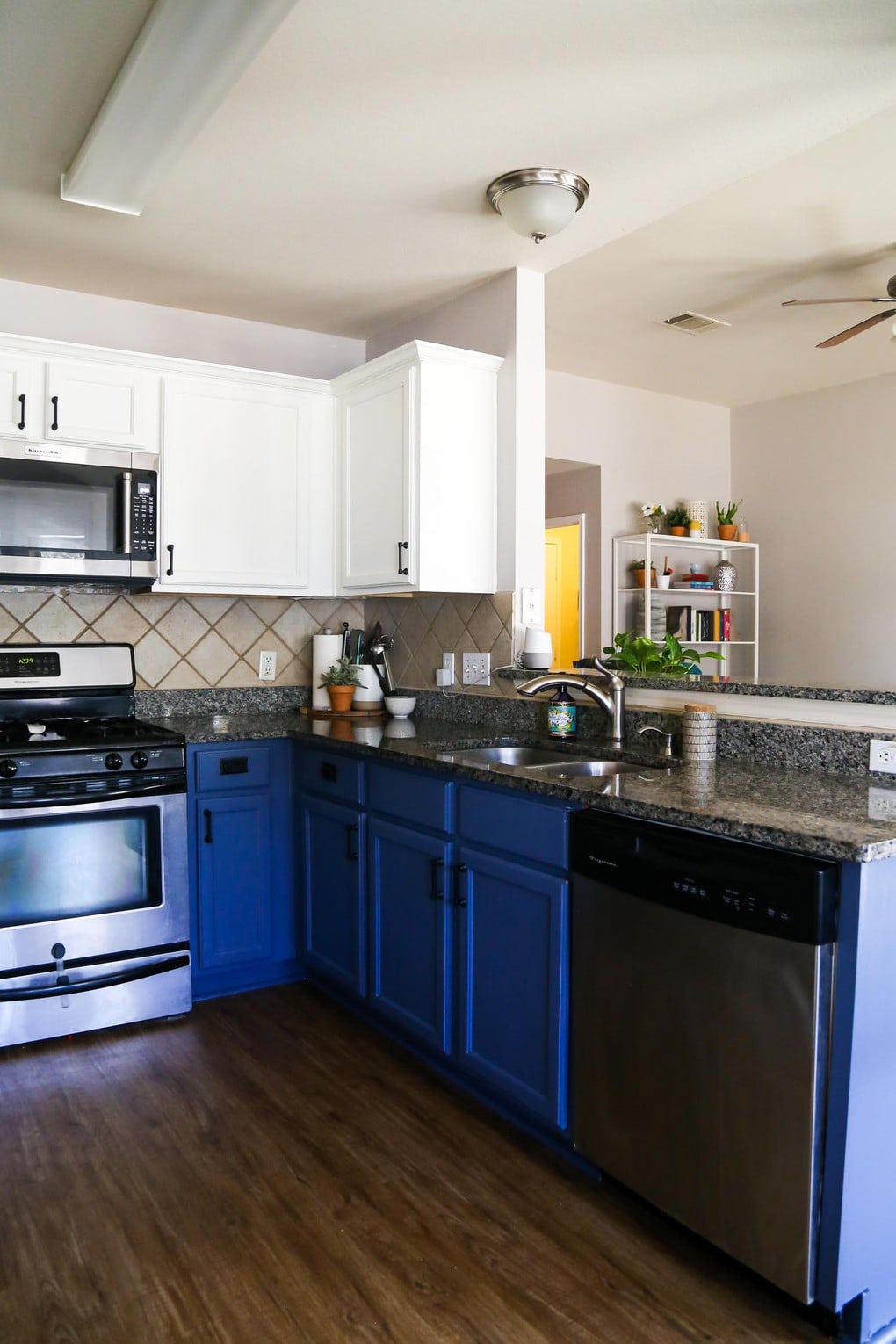 Kitchen with blue and white cabinets and Mohawk vinyl plank flooring on the floor