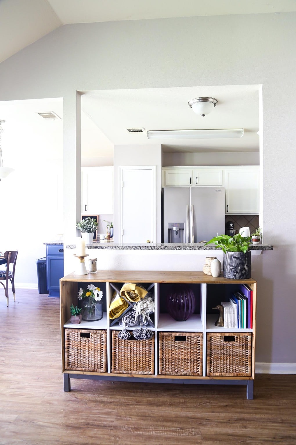 Image looking into a kitchen with a wood credenza sitting under the bar