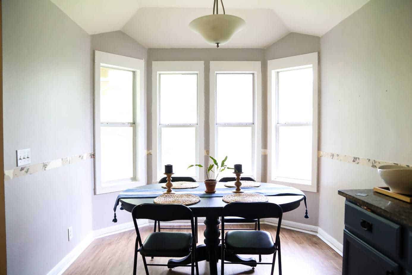 Dining room with DIY window trim and a hidden trash can