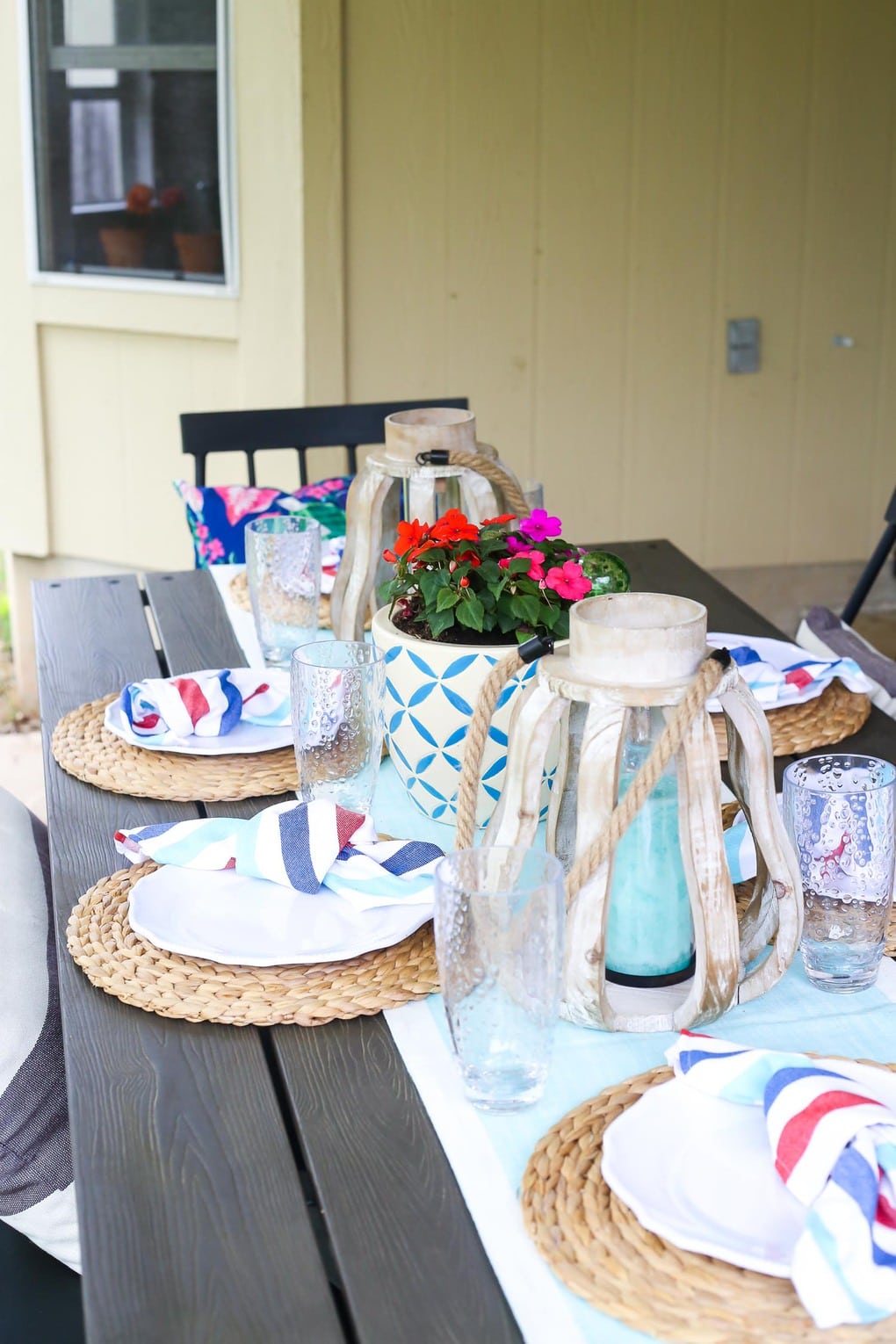 Patio table with red and purple flowers and white plates