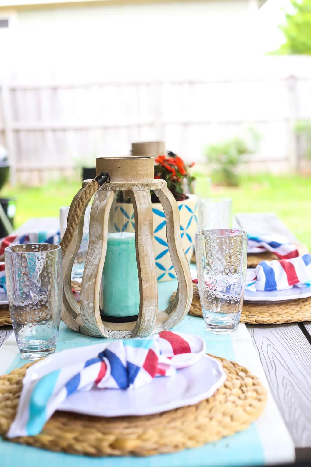 Patio table set with white plates and wood decor