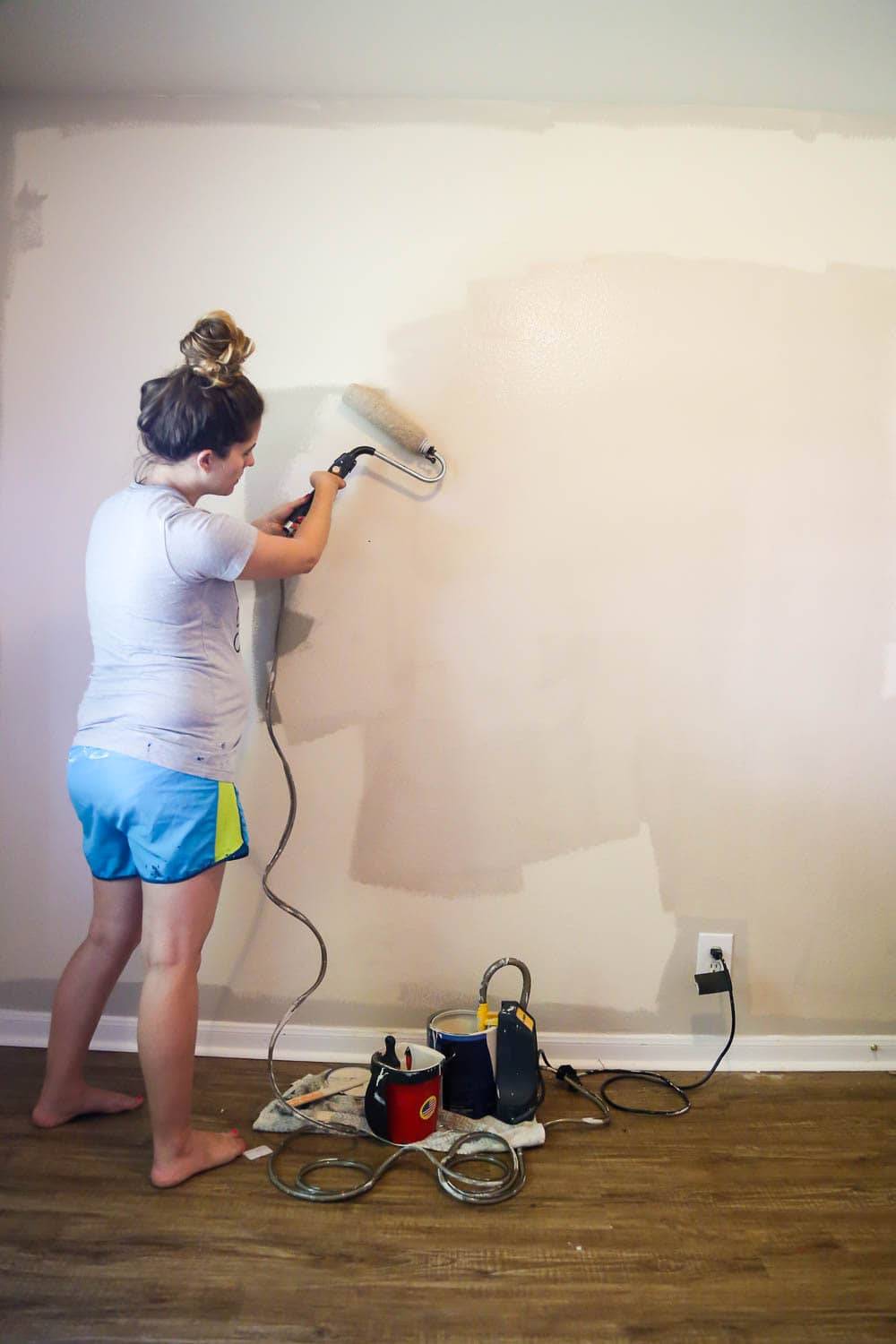 woman painting a wall with a Wagner Sidekick power roller