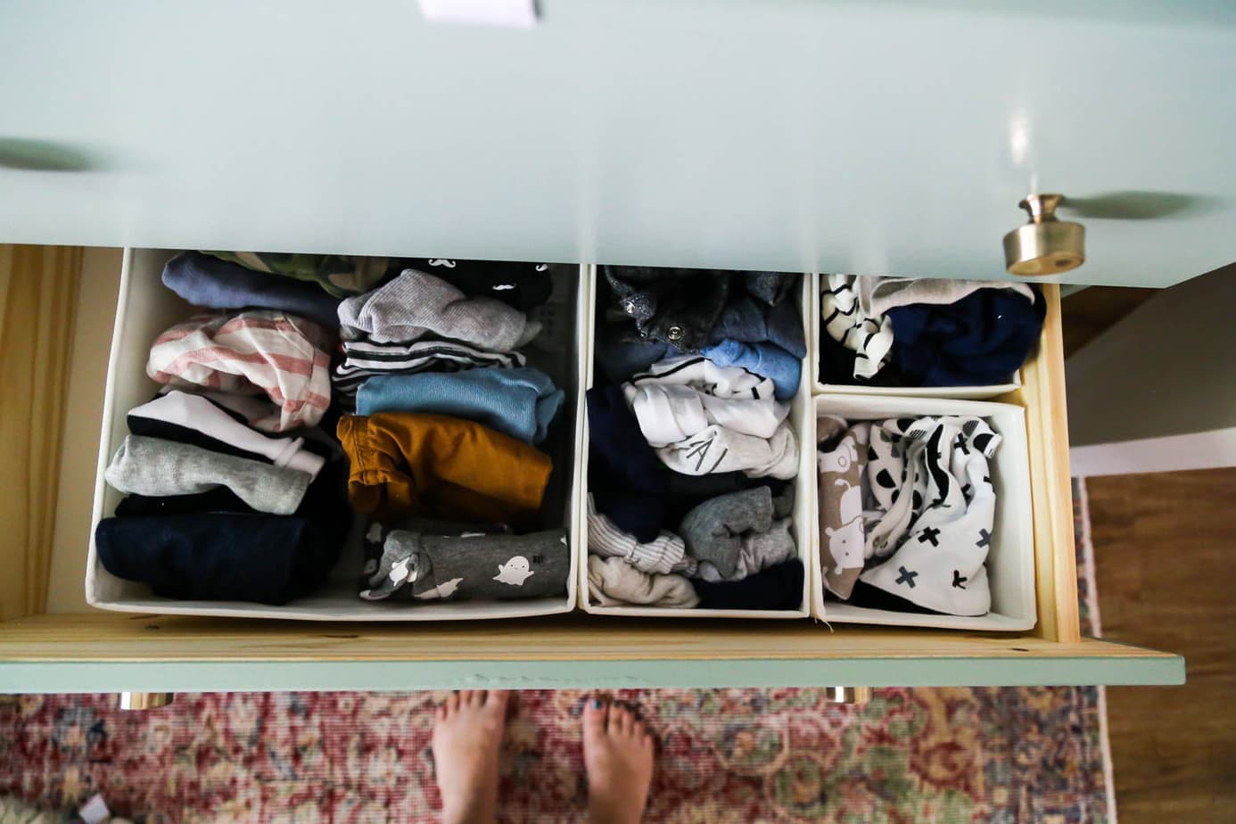 organizing clothes in nursery dresser