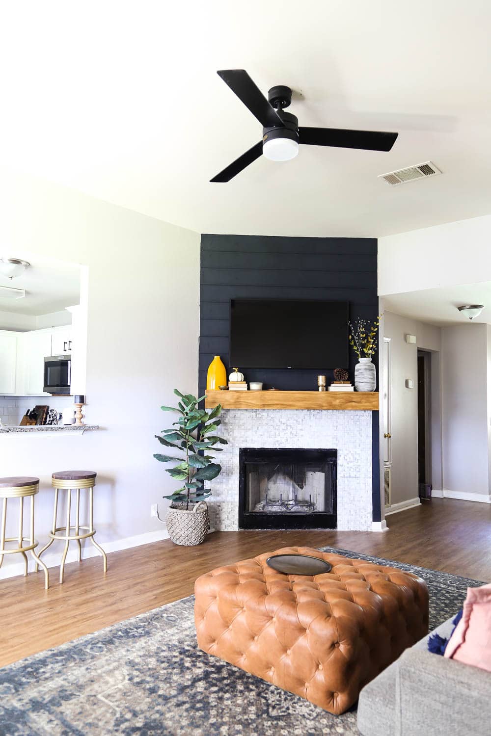 a living room with a black shiplap fireplace