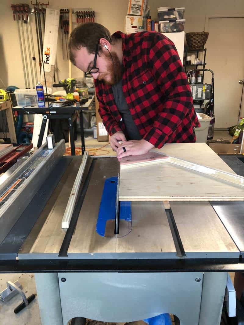 man using table saw to cut wood for diy christmas tree