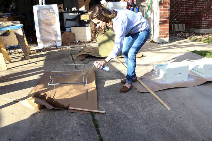 woman spray painting metal filing cabinet