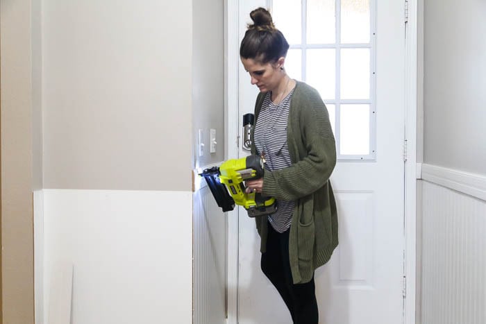 woman installing trim in entryway