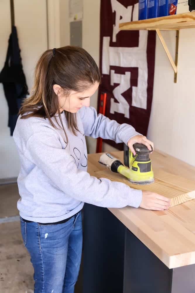 woman sanding on a work bench