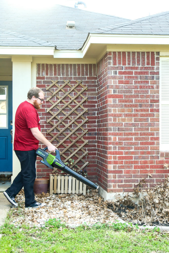 man blowing leaves in yard