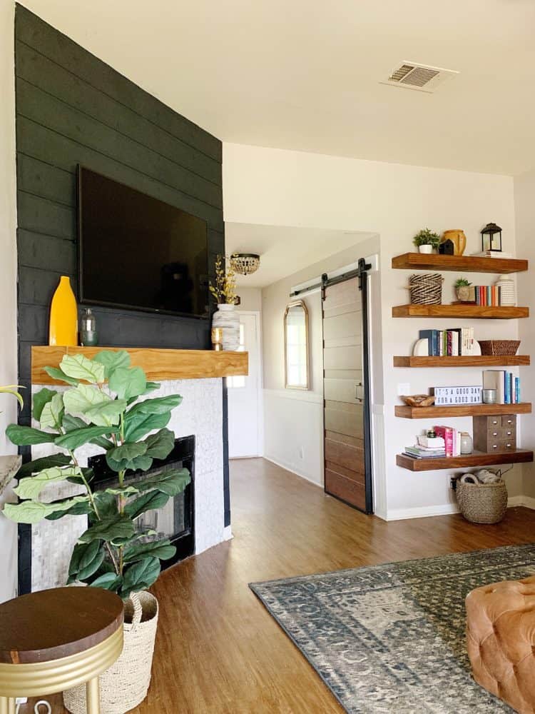 living room with black fireplace and floating shelves