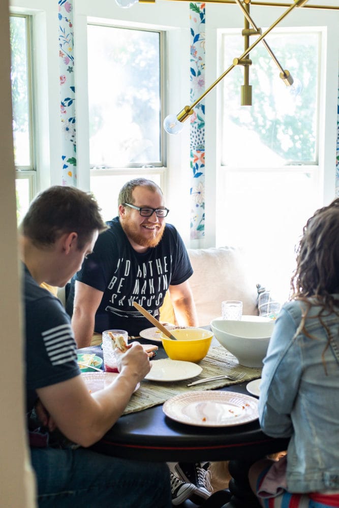 three people gathered around a table eating a meal