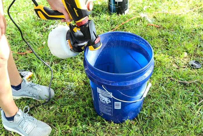 woman cleaning paint sprayer