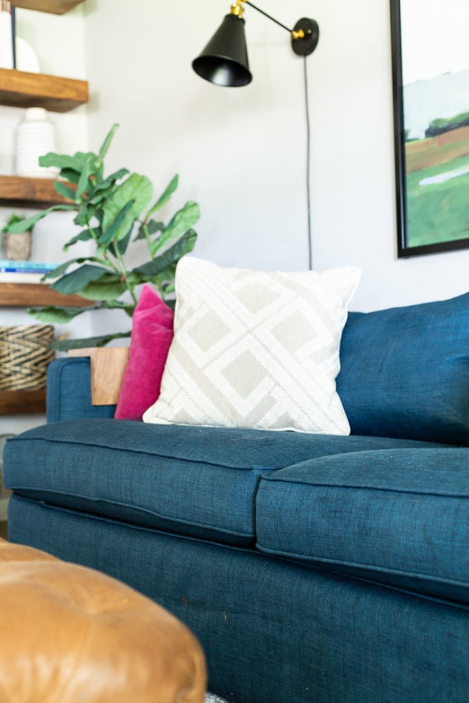 Close shot of a living room sofa with a Comfort Works slipcover on it and colorful throw pillows