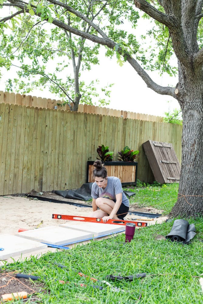 woman laying pavers in patio