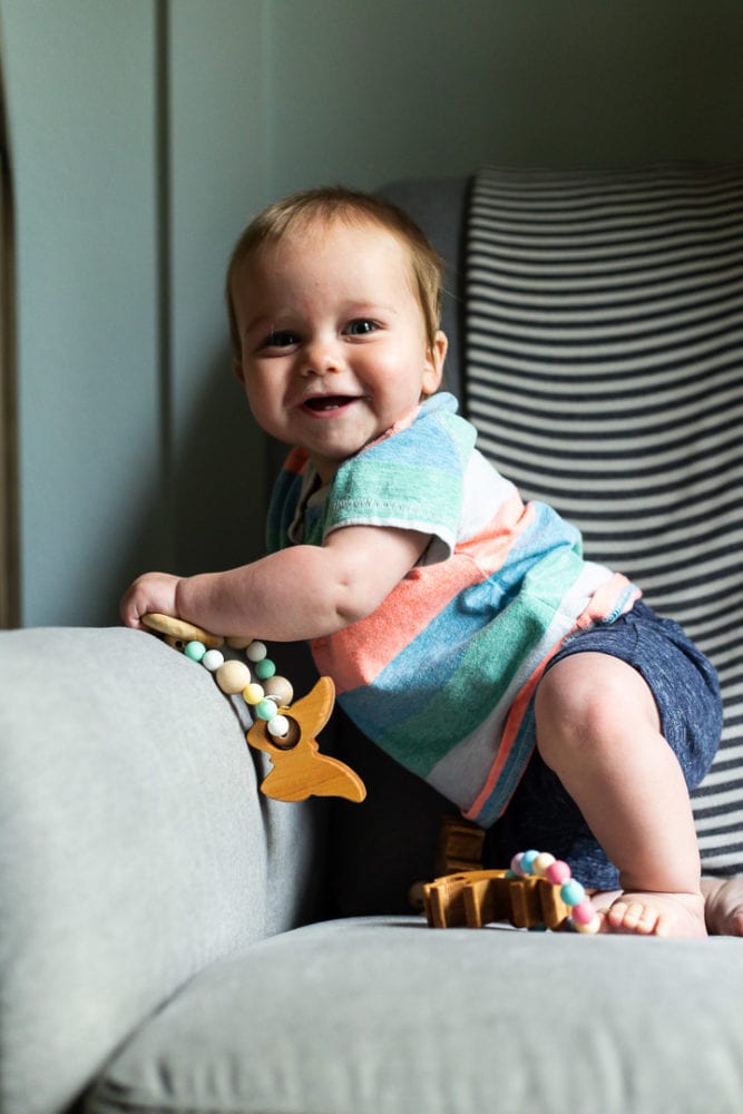 Smiling baby holding a teething toy