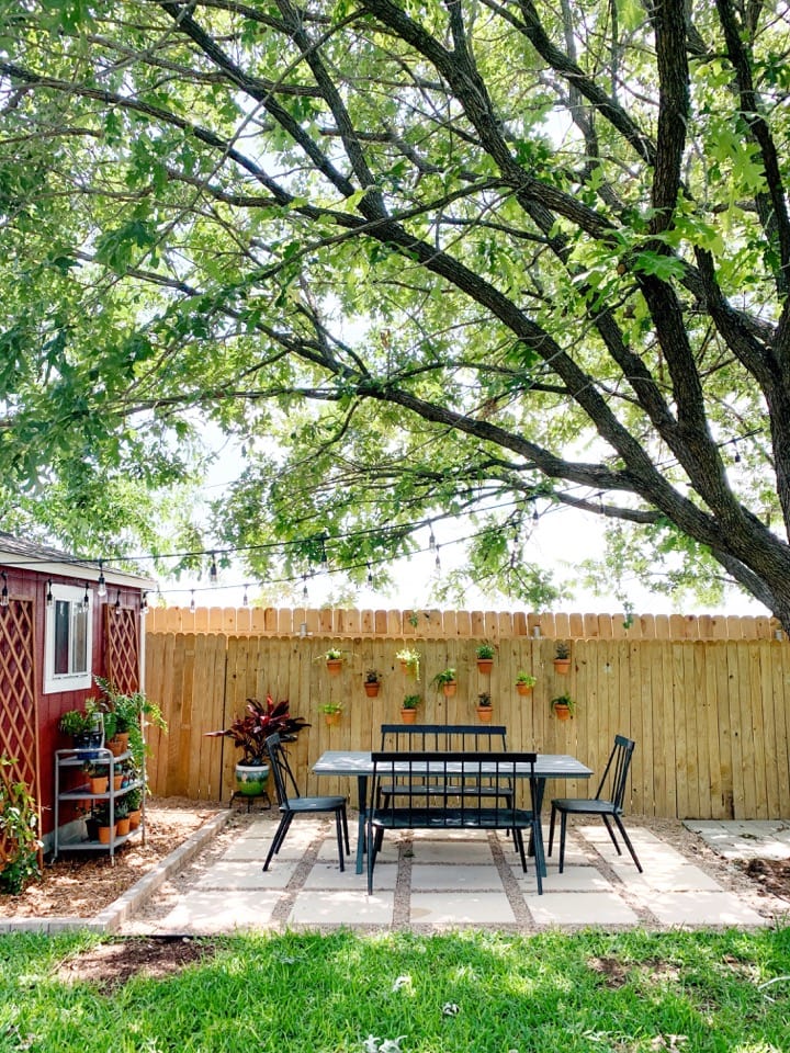 paver and pea gravel patio with dining table and lots of plants