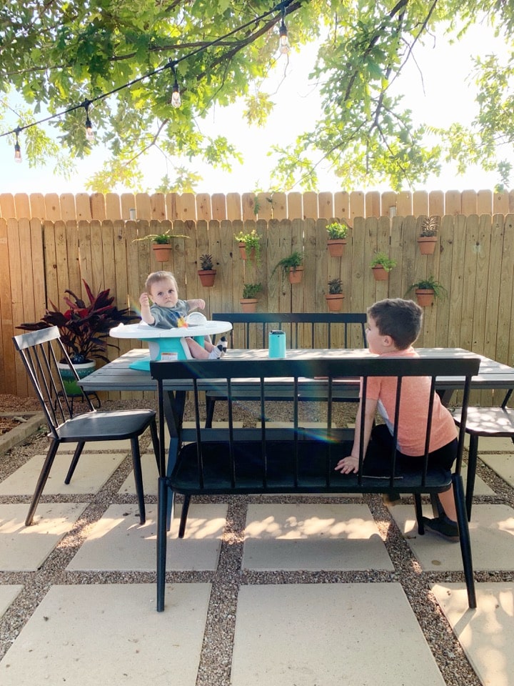 pea gravel patio with two young boys at a dining table