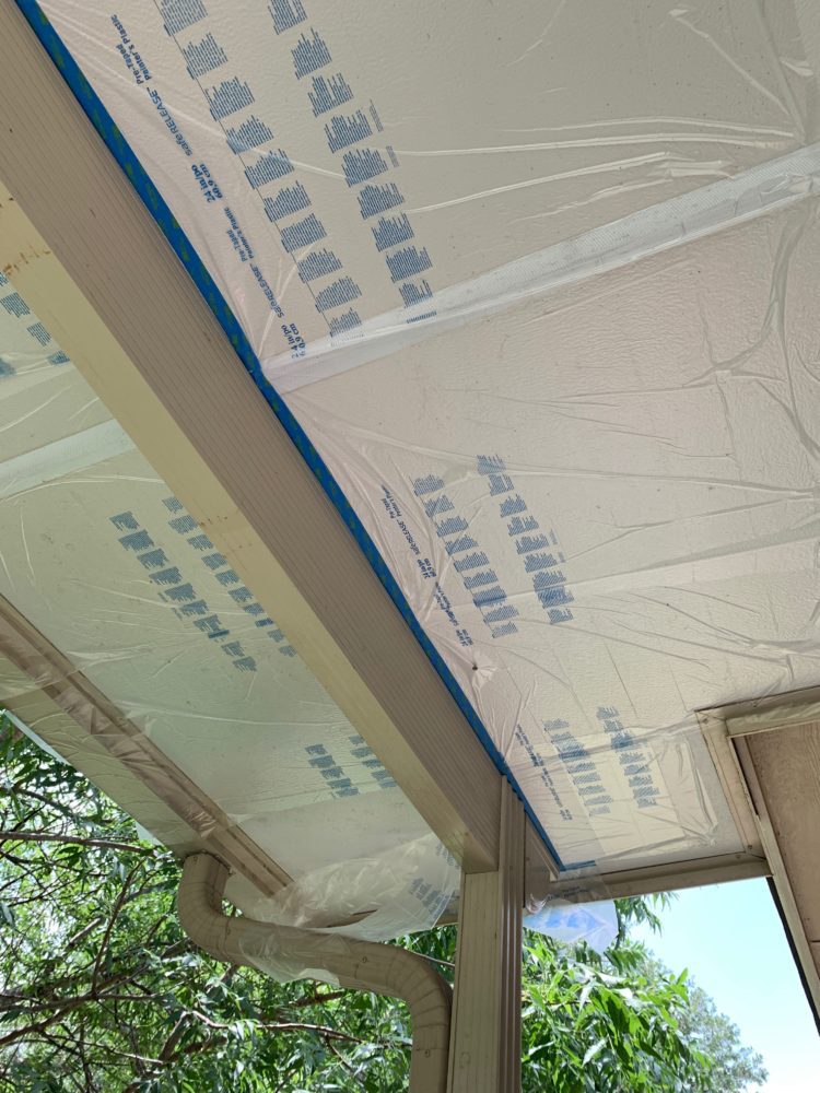 a metal patio cover taped off and prepped for paint 
