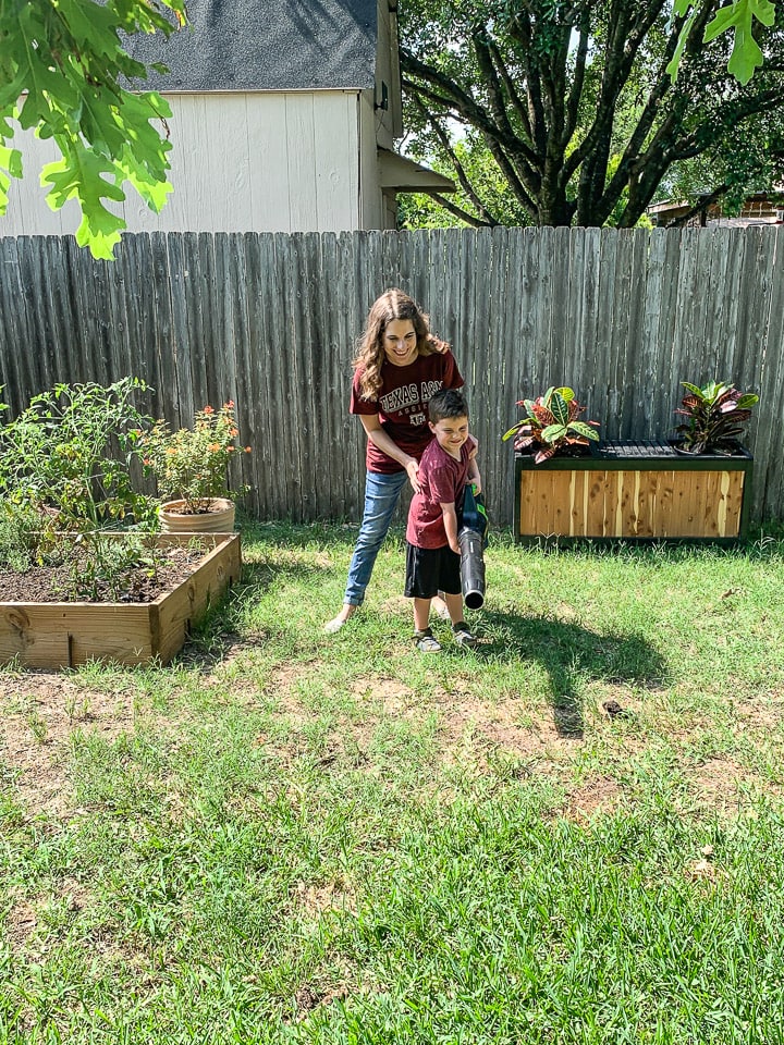 woman and young boy blowing leaves