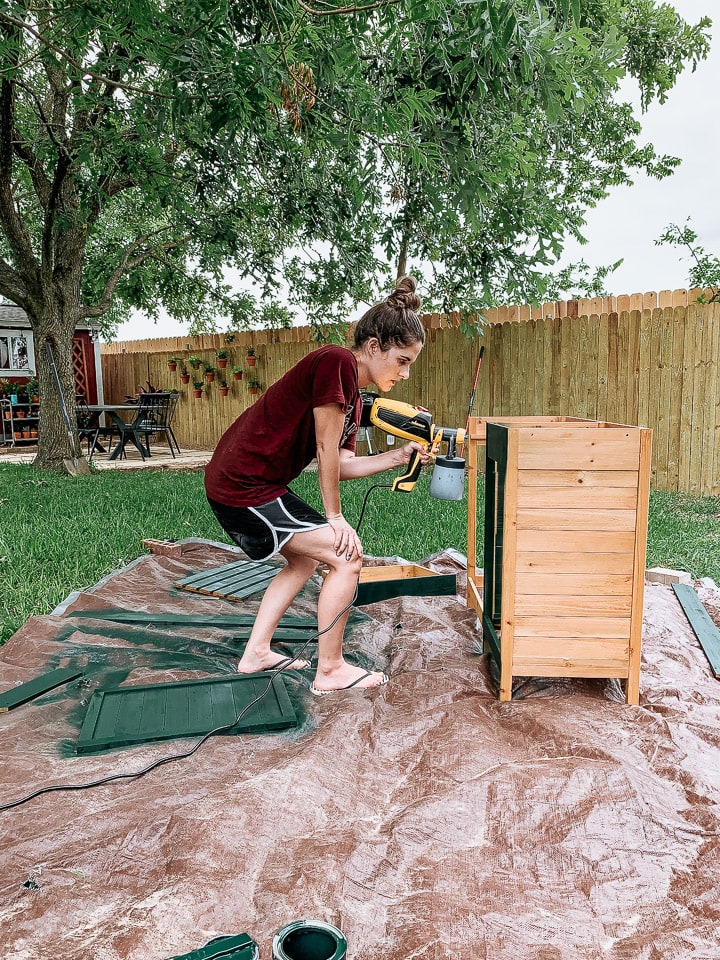 woman painting a grill cart using a Wanger sprayer