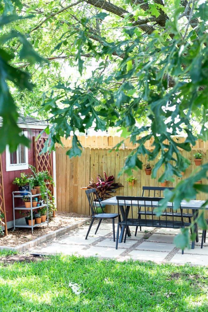 pea gravel and paver patio seen through leaves in a tree