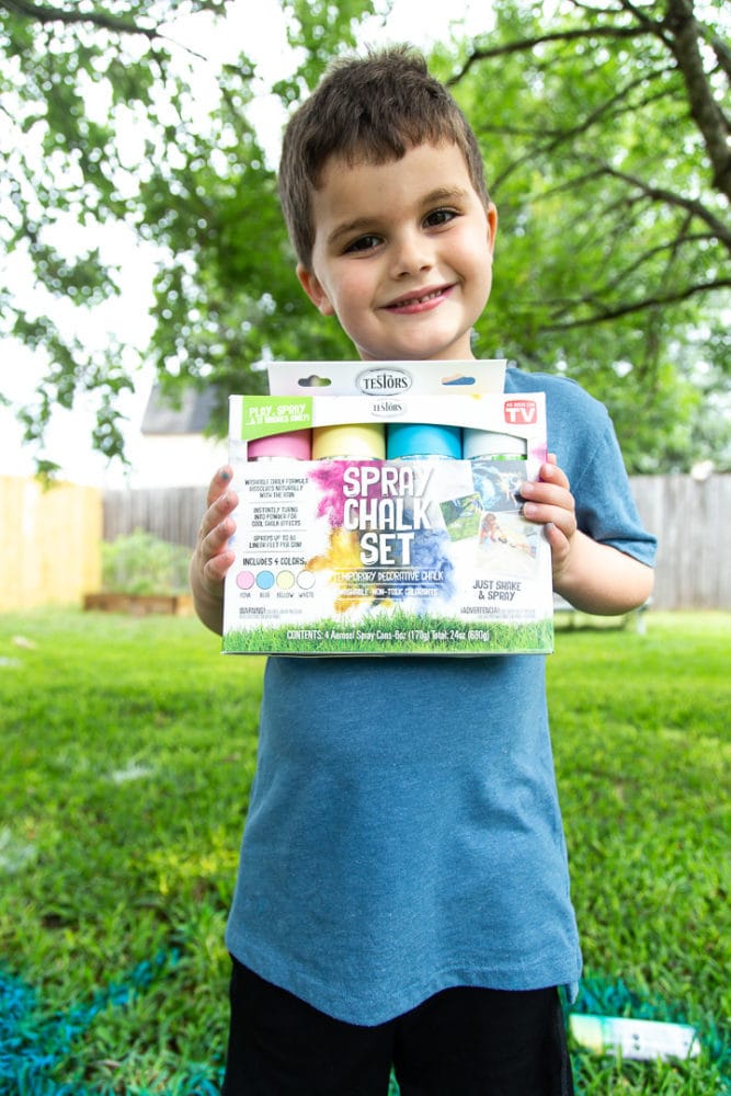 a young boy holding a box of Testors spray chalk