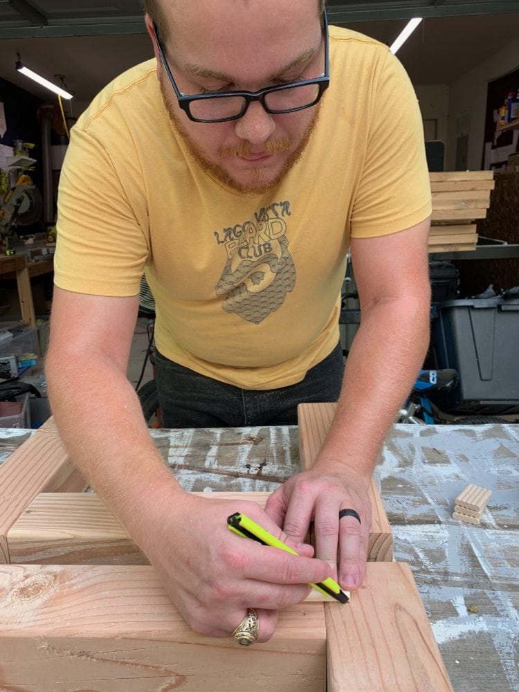 man assembling legs for an outdoor coffee table