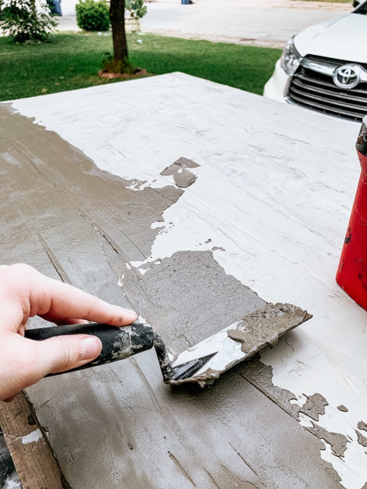 hand applying concrete feather finish to a table top