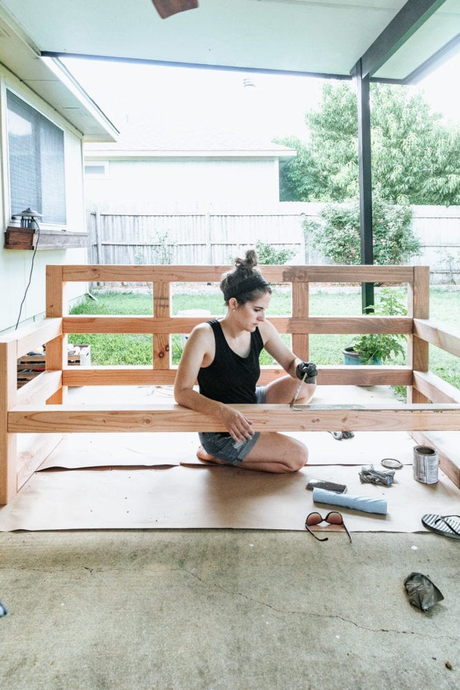 woman staining an outdoor sofa