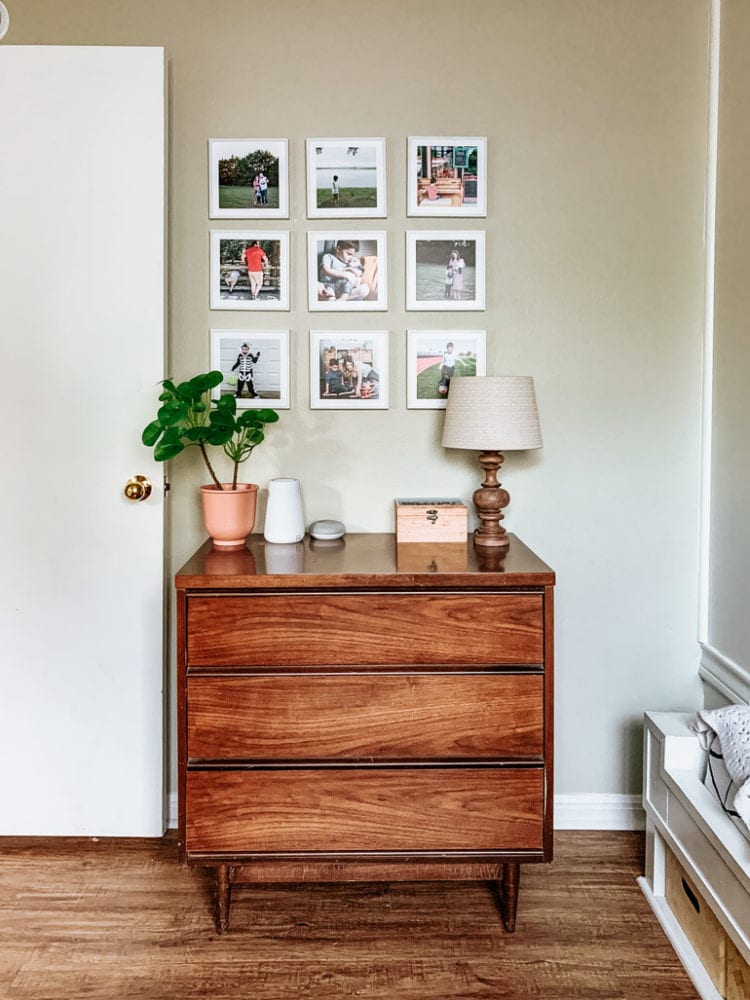 a wall in a child's bedroom with a grid of family photos on the wall