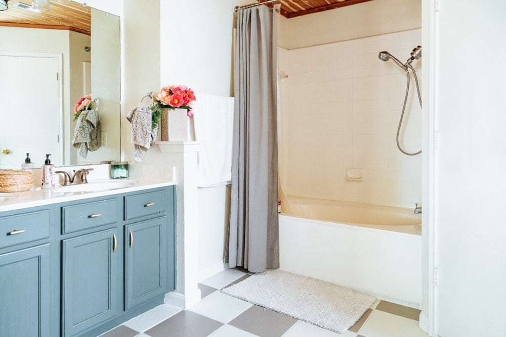 bathroom with painted bathtub, vanity, and flooring