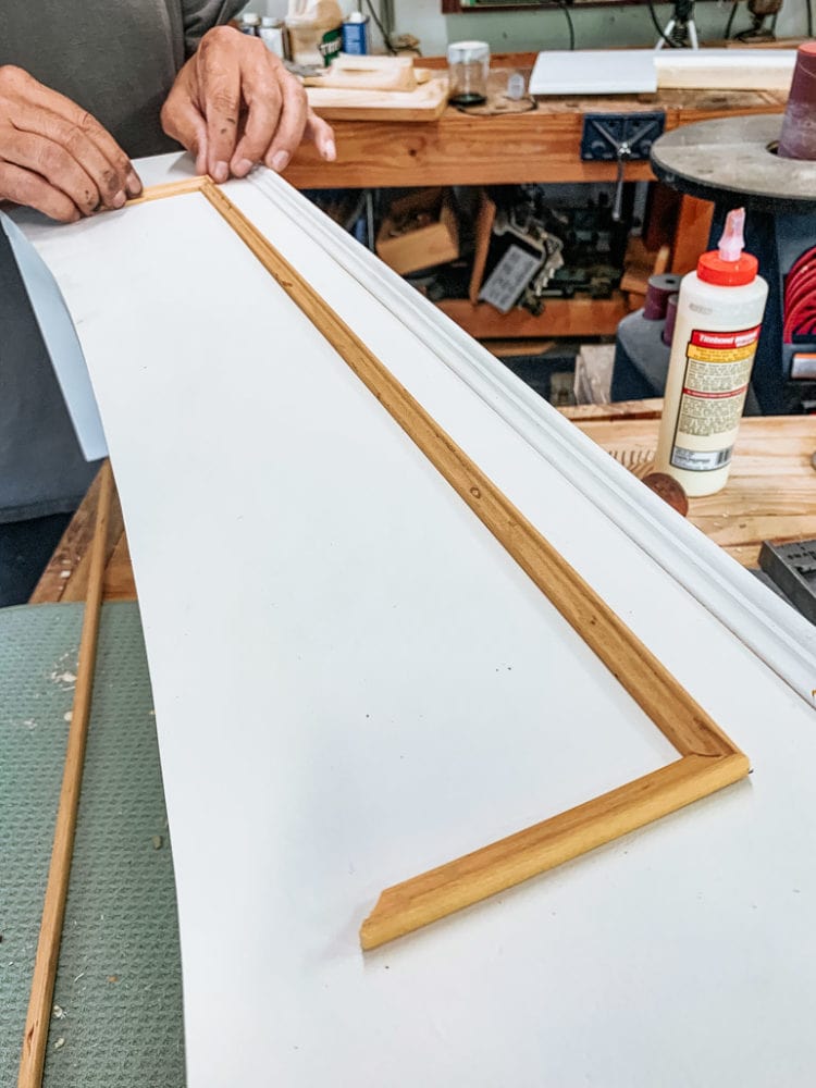 man adding trim to front of vent hood cover